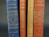 three old books sitting on top of each other on a table