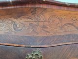 a wooden chest of drawers with a carved design on it