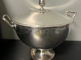 a silver bowl with a lid sitting on a table