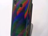 a close up of a cell phone on a stand on a white surface