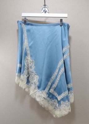 a blue skirt with white lace on it hanging on a hanger