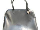 a close up of a black handbag on a white surface