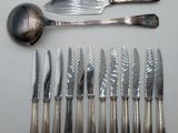a lot of knives and spoons that are on the table