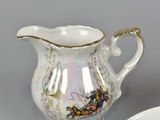 a small pitcher and a small bowl on a table