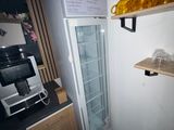 un réfrigérateur dans un coin de la cuisine, avec une étagère au-dessus