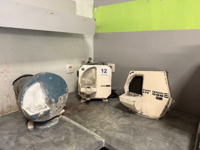 trois lavabos dans une petite pièce aux murs verts et blancs