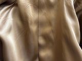 the back of a tan leather jacket with a blue label on it