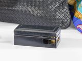 un sac à main noir et un sac à main noir posés sur une table blanche