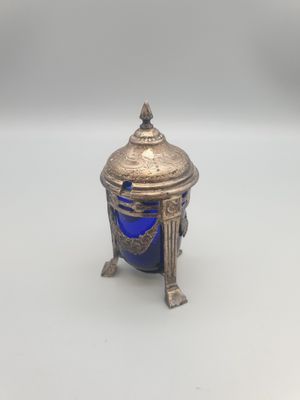 un bocal ancien en argent et en verre bleu, posé sur un socle