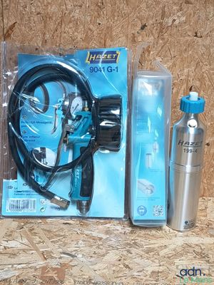 un kit comprenant un tuyau, un pistolet pulvérisateur et une bouteille d'eau