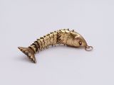 a close up of a gold fish shaped object on a white surface
