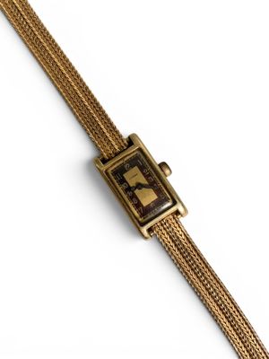 un gros plan d'une montre sur une surface blanche avec un fond blanc