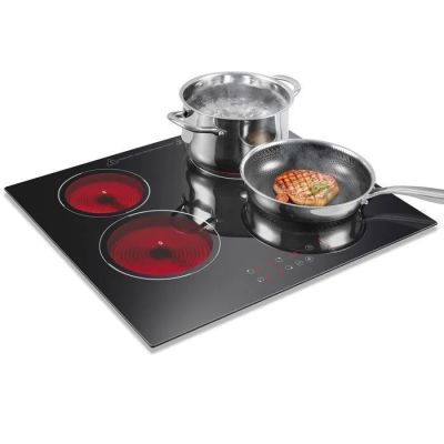 trois casseroles et poêles posées sur une plaque de cuisson
