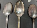 several spoons and spoon knives are lined up on a table