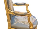 a gold and blue chair with a blue cushion on it