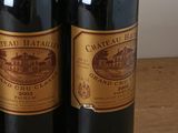 three bottles of wine sitting on a wooden table next to each other