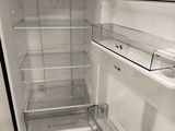 an open refrigerator with the door open and no food inside