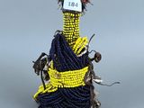 une photo d'une figurine représentant une femme en robe bleue avec une ceinture jaune