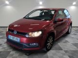 the red volkswagen polo is parked on a checkered tile floor