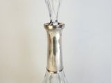 un vase en verre posé sur une table, avec un socle en argent