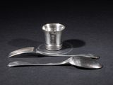 two forks and a silver cup on a black table
