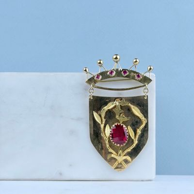 une photo d'une broche surmontée d'une couronne