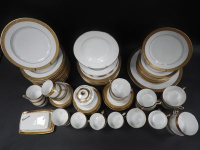 a lot of white and gold plates and bowls
