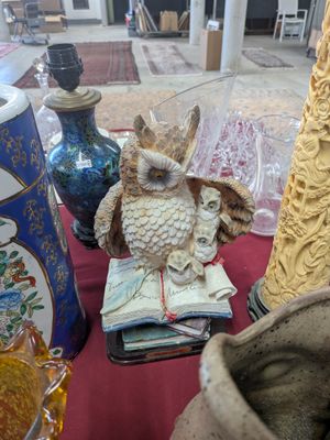 a table with vases and a statue of an owl on it
