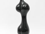a close up of a black sculpture on a white background