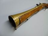 an old brass trumpet with a wooden handle on a white surface