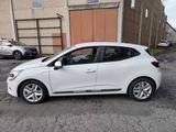 the white car is parked in the parking lot near the building