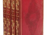 trois livres rouges aux tranches dorées sont empilés les uns sur les autres