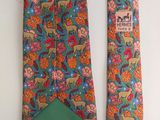 two neck ties with animals and flowers on them hanging on a wall