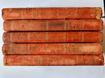 six old books are stacked on top of each other on a table