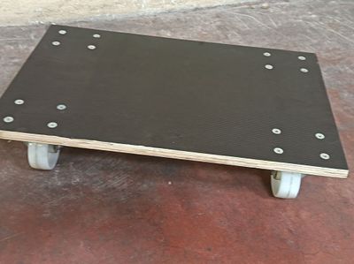 une petite table en bois munie de roulettes, posée sur un sol en béton