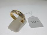 gros plan d'une bague sur une surface blanche avec une étiquette de prix