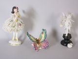trois figurines représentant une fée et une fée assise sur une table