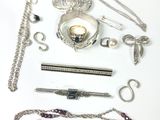 beaucoup de bijoux en argent sur une surface blanche