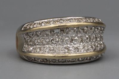 une photo d'une bague en diamant posée sur une surface grise