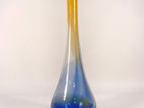 a blue and yellow vase sitting on a white surface