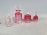 trois petites bouteilles en verre roses posées les unes à côté des autres sur une surface blanche