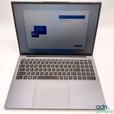 un ordinateur portable ouvert posé sur une table blanche