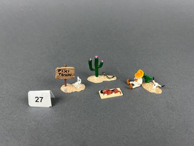 trois petites figurines représentant des animaux du désert et un panneau