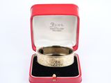 a gold ring in a red box on a white surface