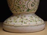 a white vase with a floral design on it on a table