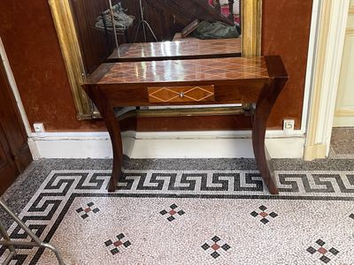 une petite table sur laquelle est posé un miroir, dans un coin de la pièce
