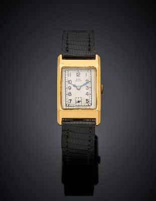 a gold plated wrist watch with a black leather strap