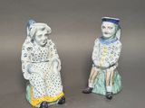 pair of ceramic figurines of a man and a woman sitting next to each other