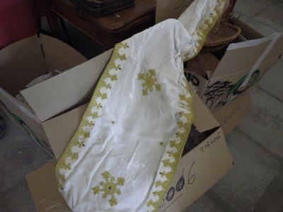 une couverture blanche et jaune dans une boîte posée par terre