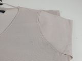 a close up of the top of a t - shirt on a hanger next to a pair of scissors